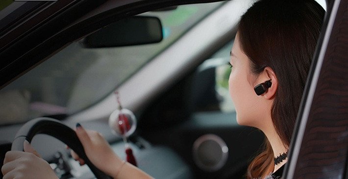 Người lái xe ô tô sử dụng tai nghe Bluetooth để đàm thoại an toàn, nhận cuộc gọi bằng tai nghe không dây