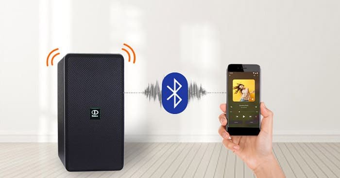 Người dùng điều khiển âm thanh loa Bluetooth qua điện thoại, minh họa khả năng kiểm soát nhờ app phá sóng Bluetooth.