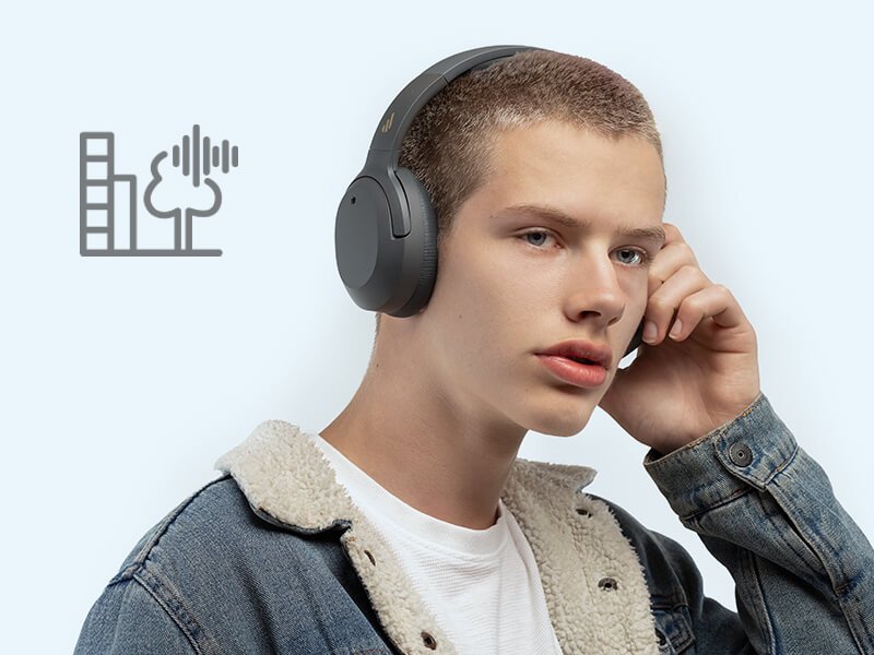 Người mẫu đeo tai nghe Edifier W820NB trong môi trường sân bay, minh họa chế độ xuyên âm giúp nhận biết âm thanh xung quanh.