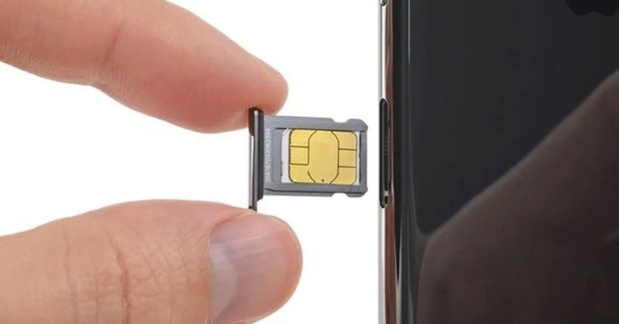Thao tác tháo thẻ SIM từ khe cắm điện thoại, chuẩn bị cho việc chuyển danh bạ.