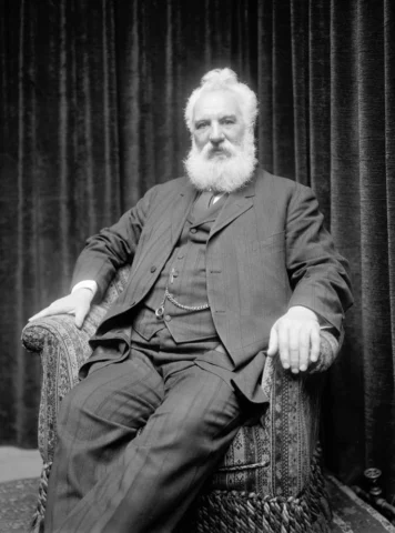 Alexander Graham Bell bên cạnh chiếc điện thoại sơ khai